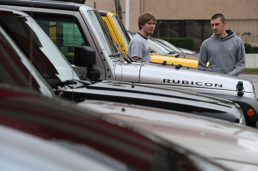 Car shoppers inspect a row of Jeep Wranglers
