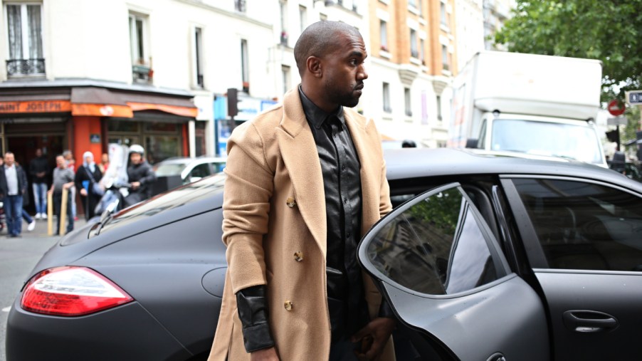 Kanye West getting into the back seat of a car