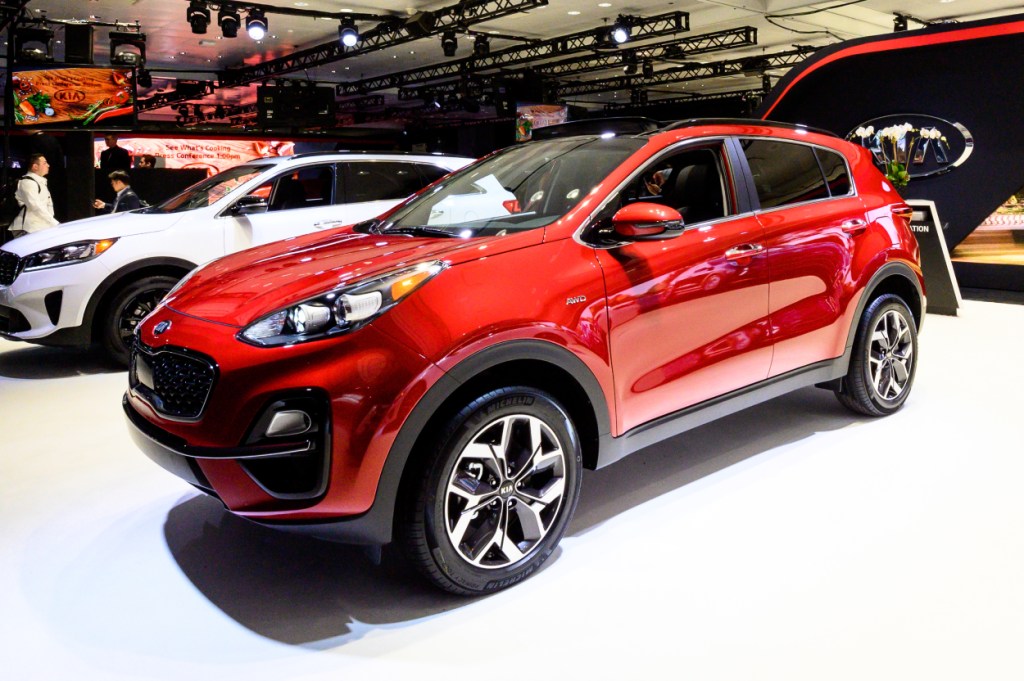 A red Kia Sportage on display at an auto show