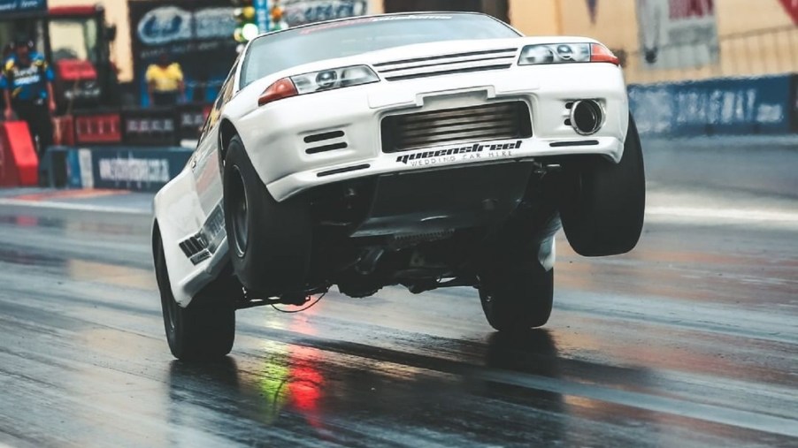 Maatouks Racing's white 2100-hp R32 Nissan Skyline GT-R drag race car pulling a wheelie on the drag strip