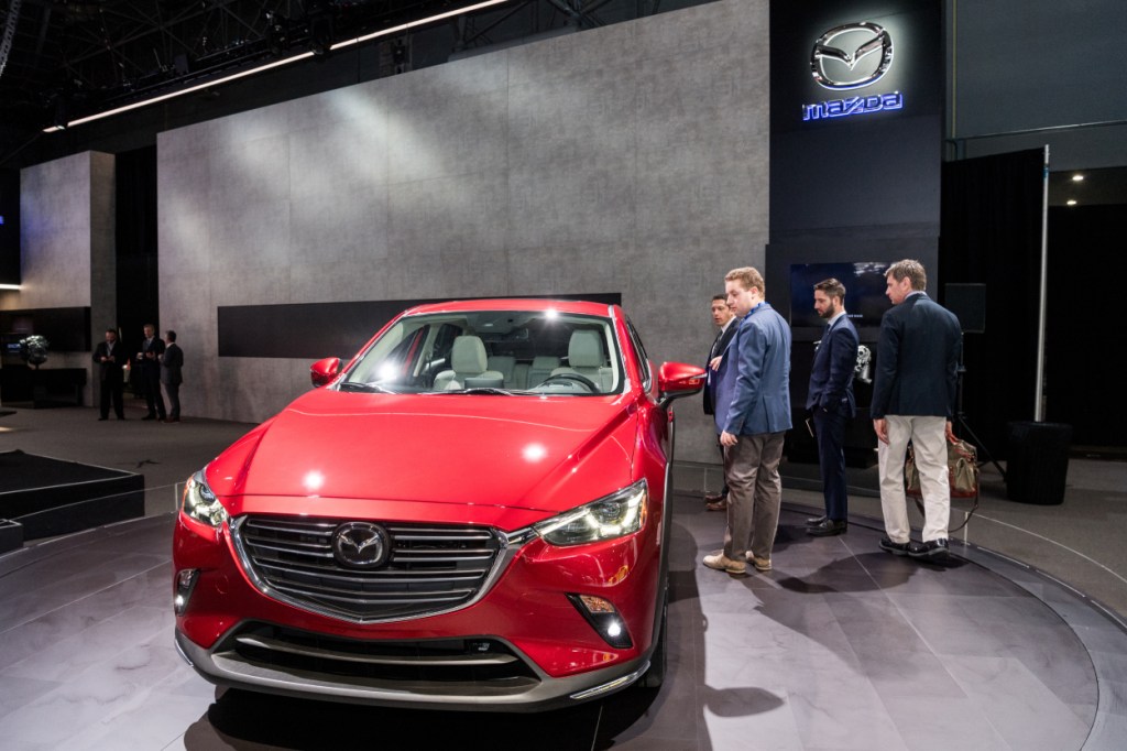 People inspecting a Mazda CX-5 at an auto show