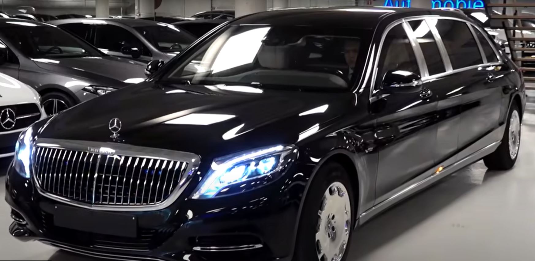 A black limousine is parked in a parking garage