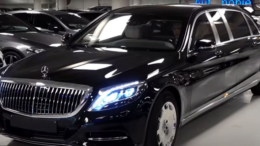 A black limousine is parked in a parking garage