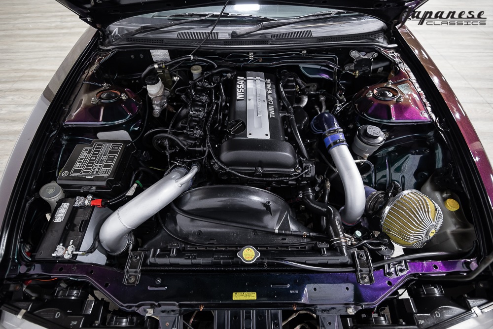 The engine bay of a modified purple 1995 S14 Nissan Silvia