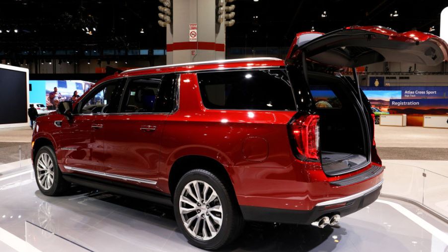A red GMC Yukon on display at an auto show