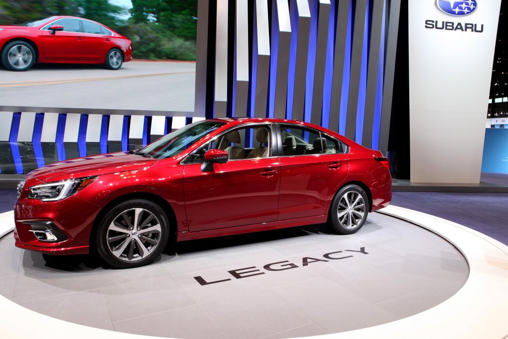 A red 2018 Subaru Legacy on display at an auto show