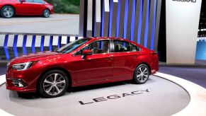 A red 2018 Subaru Legacy on display at an auto show