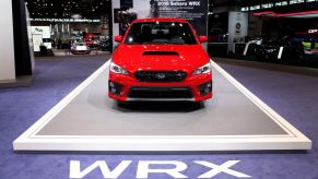 A red Subaru WRX on display at an auto show