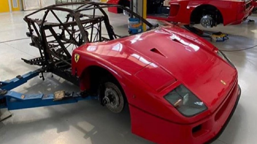 Red burned-out Ferrari F40 awaiting restoration in a shop