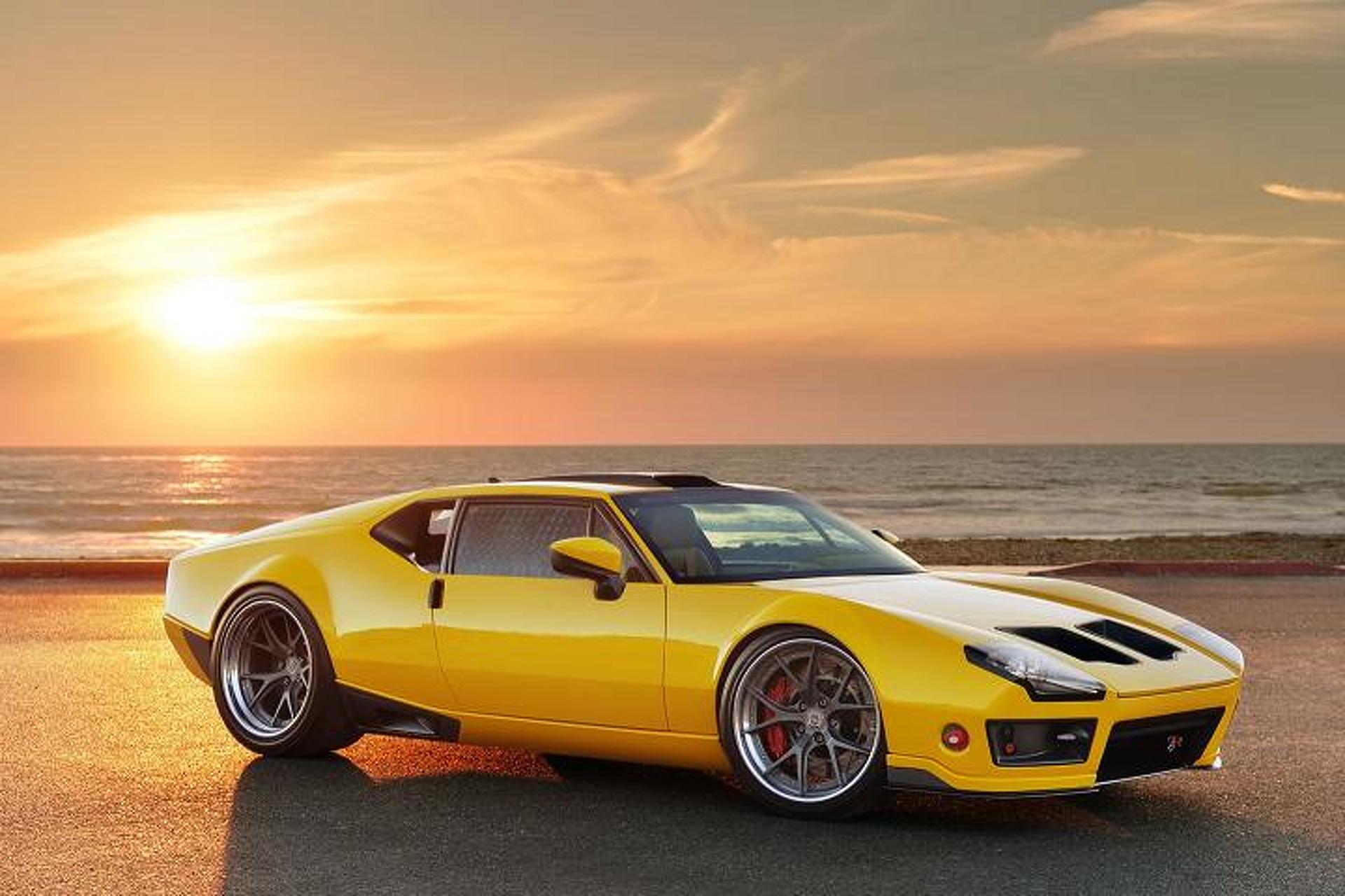 A yellow, custom, DeTomaso Pantera is parked before an ocean view.