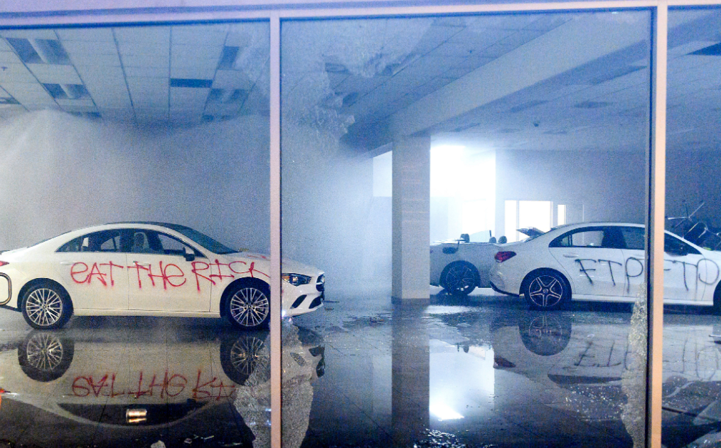 Aftermath of dodges vandalized inside of dealership with grafitti written in red spray paint