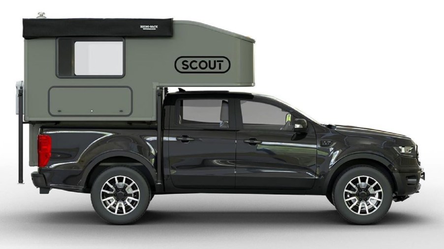 Green Scout Campers Yoho on a black Ford Ranger, viewed from the side