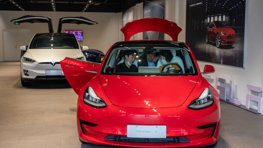 People sit in a Tesla Model 3 car at the first Tesla Center in Shanghai on May 9, 2020