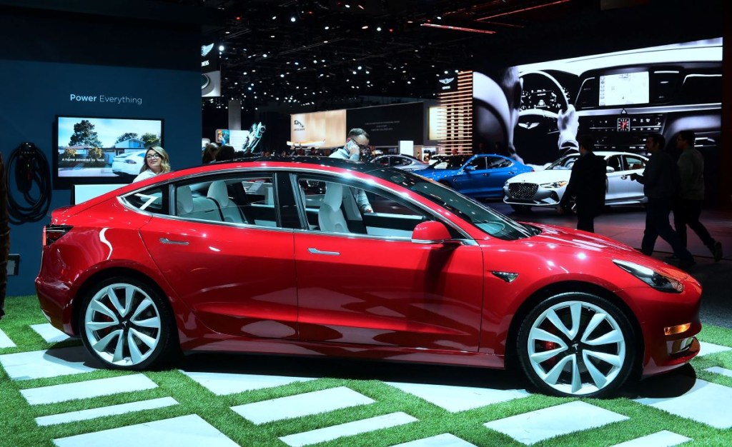 A red Tesla Model 3 electric car on display
