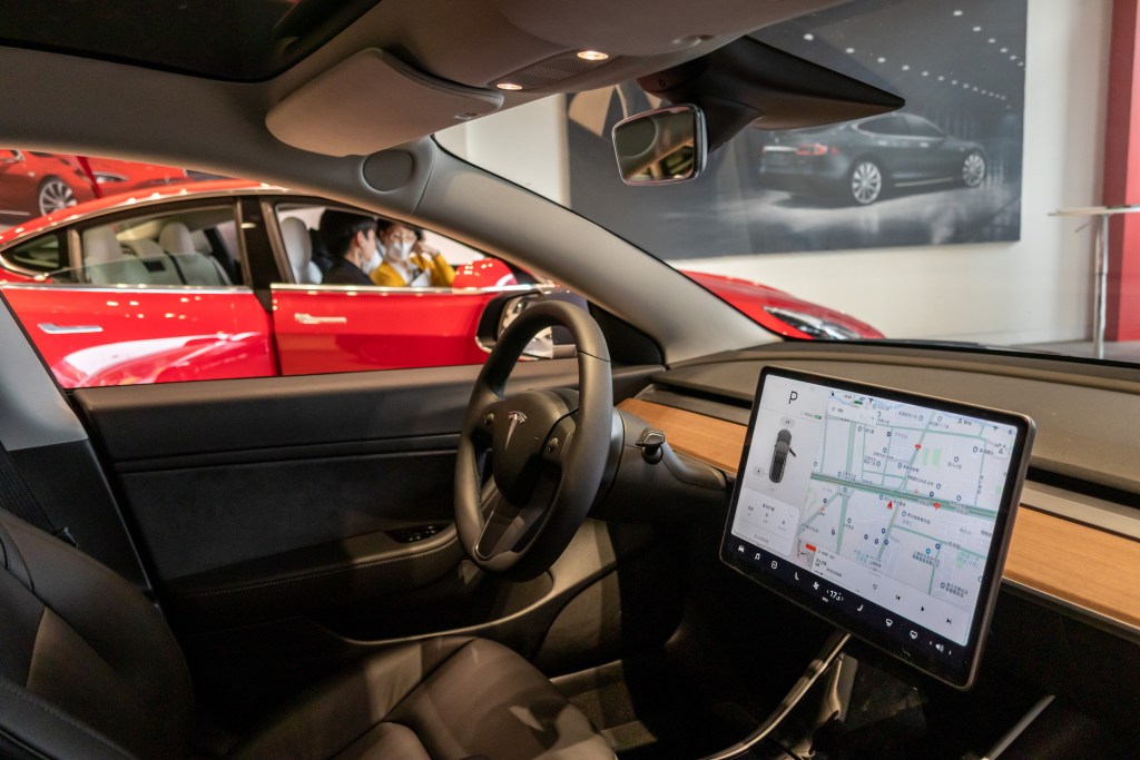 Citizens watch three models of Tesla Model 3, model X and model s in the exhibition hall of the newly opened Tesla experience center