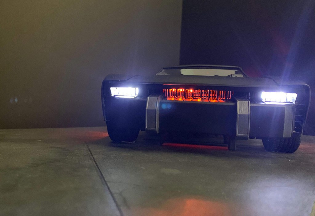 The Batman Batmobile 2021 | front view with headlights and orange glow behind grille Frost