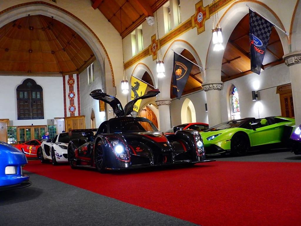 Cars line the inside of a converted church.