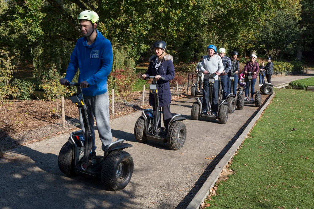 People on Segways line up to enter a castle tour.