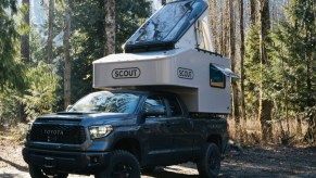 Green Toyota Tundra with Toyota Tundra with Scout Campers Olympic truck camper mounted in the bed