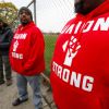 two UAW worker in red sweatshirts outside of GM