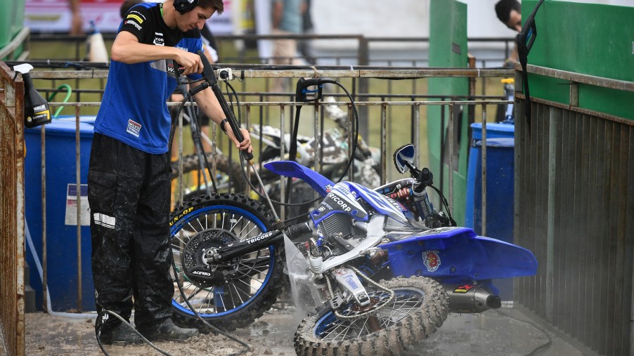 Monster Energy Yamaha Factory MXGP Team crew washes a motorcycle using a pressure washer