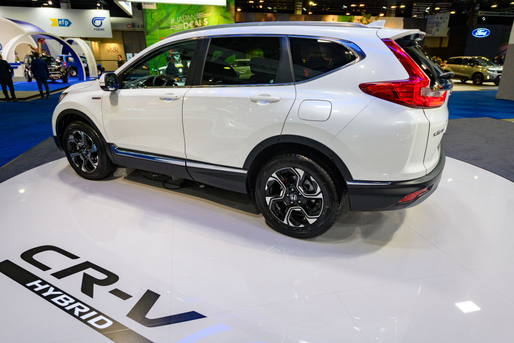 A white Honda CR-V Hybrid on display at an auto show