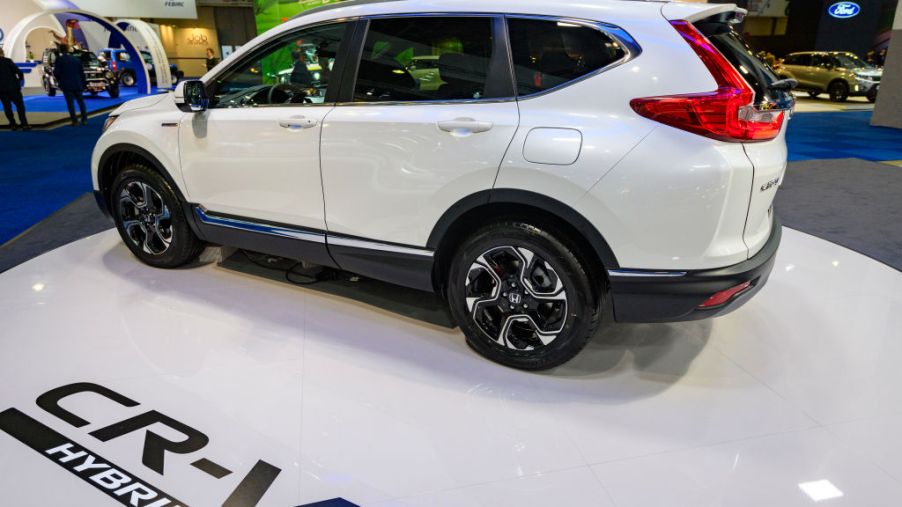 A white Honda CR-V Hybrid on display at an auto show