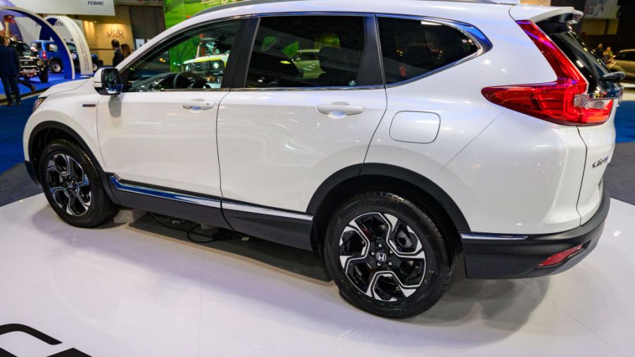 A white 2020 Honda CR-V Hybrid on display at an auto show