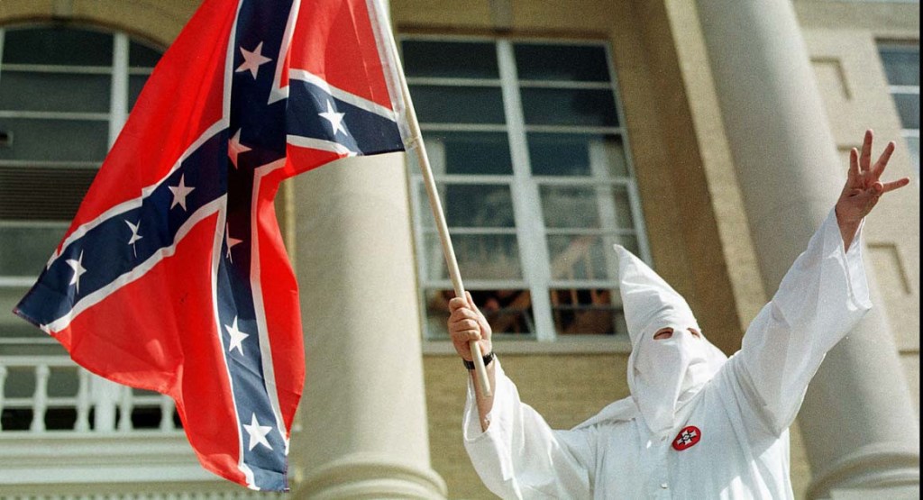 A member of the American Knights of the Ku Klux Klan waves the confederate flag during a klan rally in Indiana