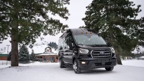 A black Ford transit passenger van in the snow