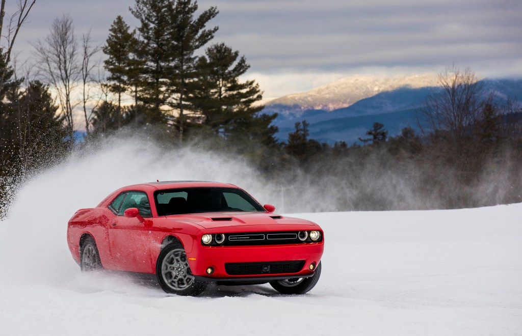 a red Dodge Challenger in the snow