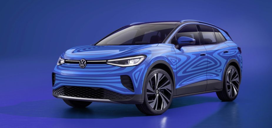 A blue Volkwagen electric SUV sits on display before a blue background.