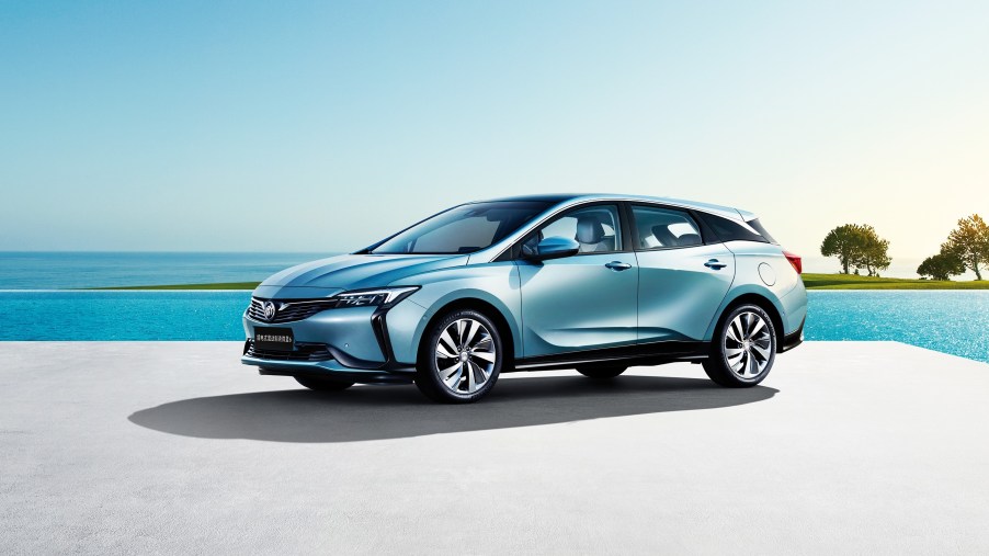 Electric light blue Buick Velite 6 PHEv parked by the ocean.