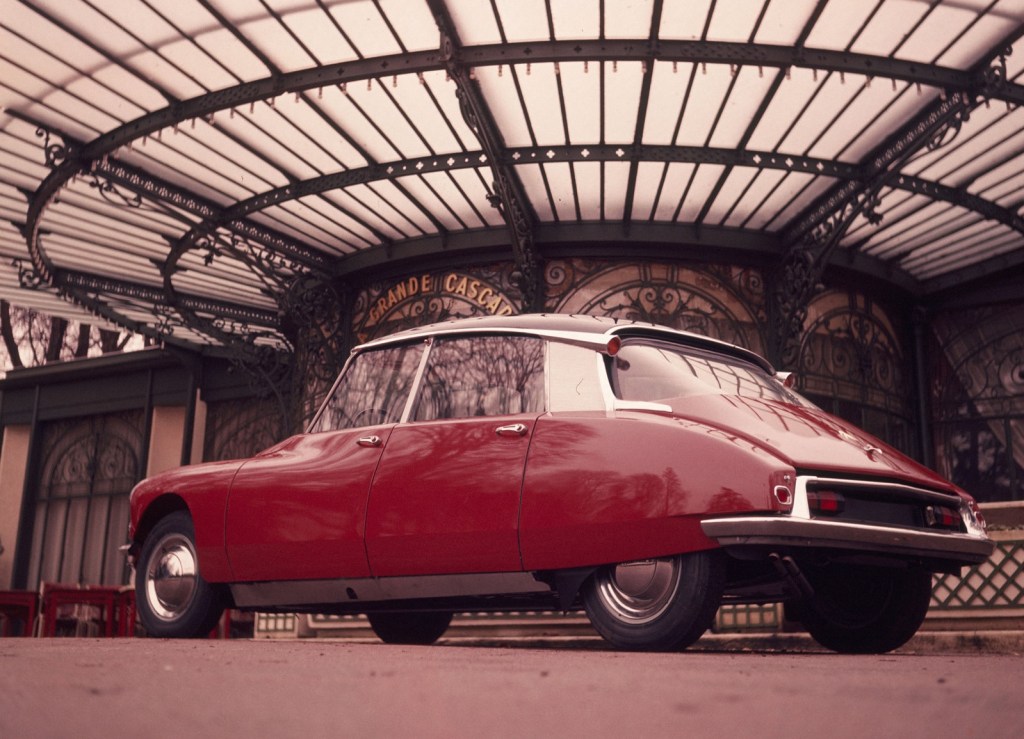 Rear low-angle view of a red 1960 Citroen DS underneath a metal-and-glass dome