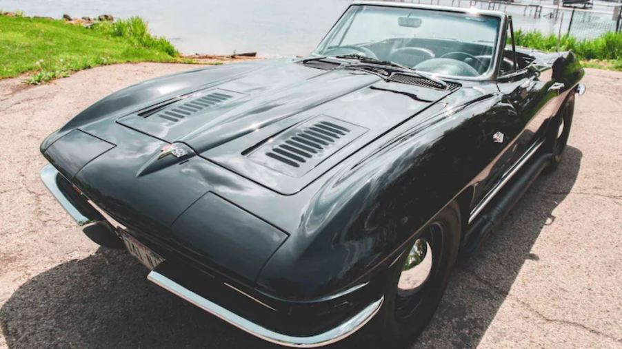 A black 1963 Chevy Corvette Sting Ray Convertible by a pier.