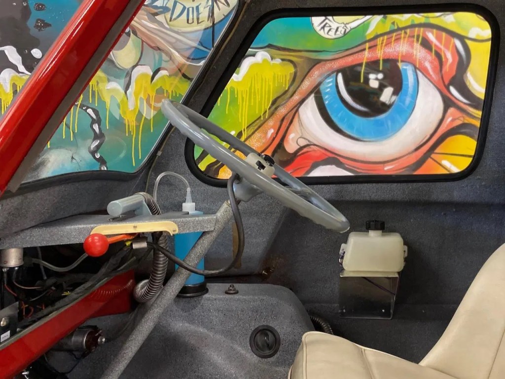Side-shot of a 1964 Peel P50's interior, showing the steering wheel and single seat
