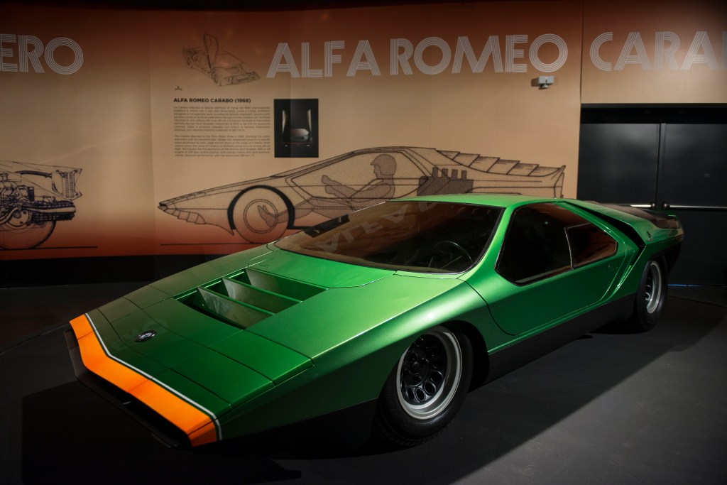 A green low slung sports car from Alfa Romeo sits in an exhibit.