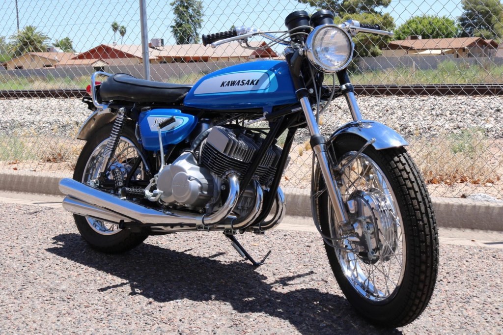 Blue 1971 Kawasaki H1 Mach III in front of a chain-link fence