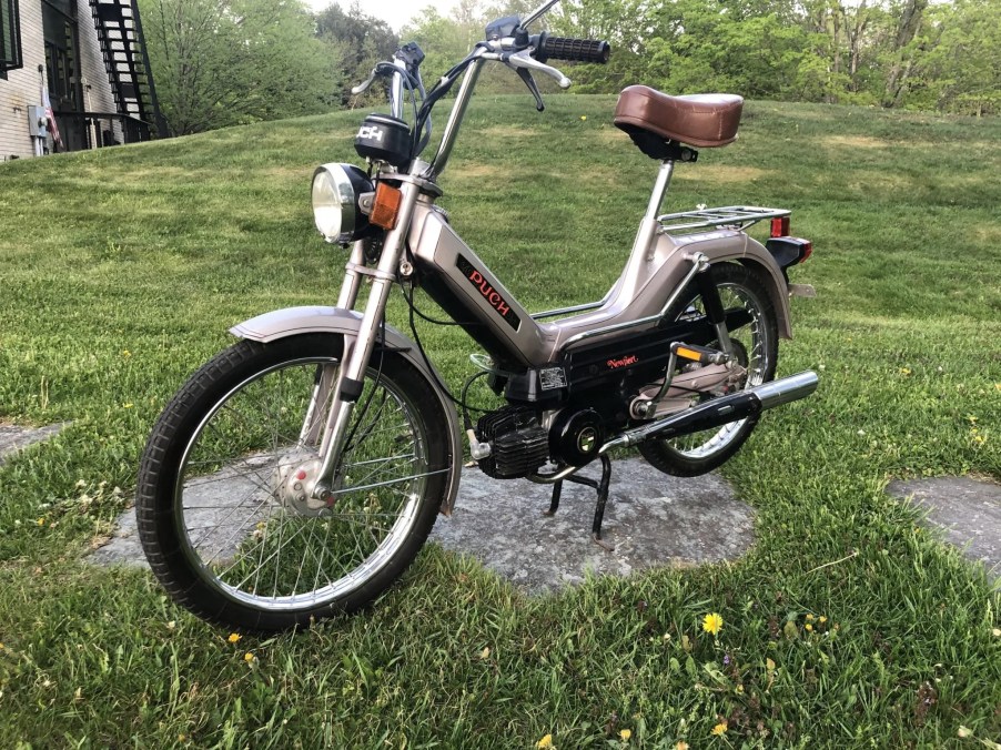Tan 1978 Puch Maxi Newport moped in the grass