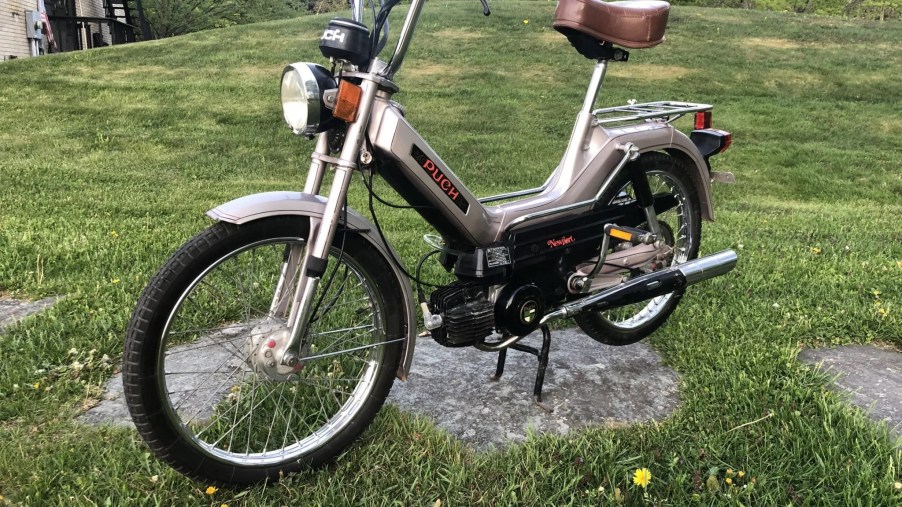 Tan 1978 Puch Maxi Newport moped in the grass