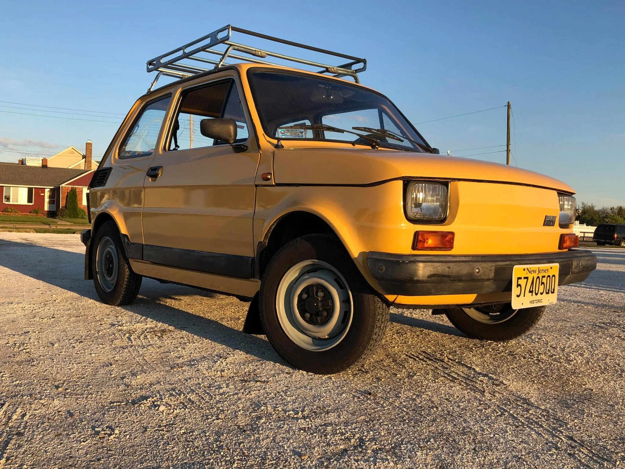 Yellow 1989 Fiat 126p hatchback with a roof rack on the beach