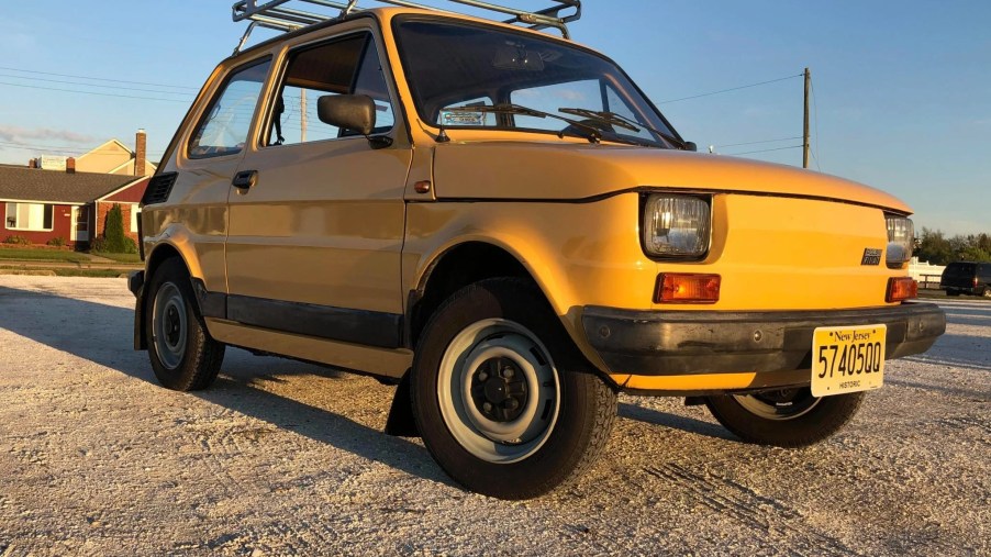 Yellow 1989 Fiat 126p hatchback with a roof rack on the beach