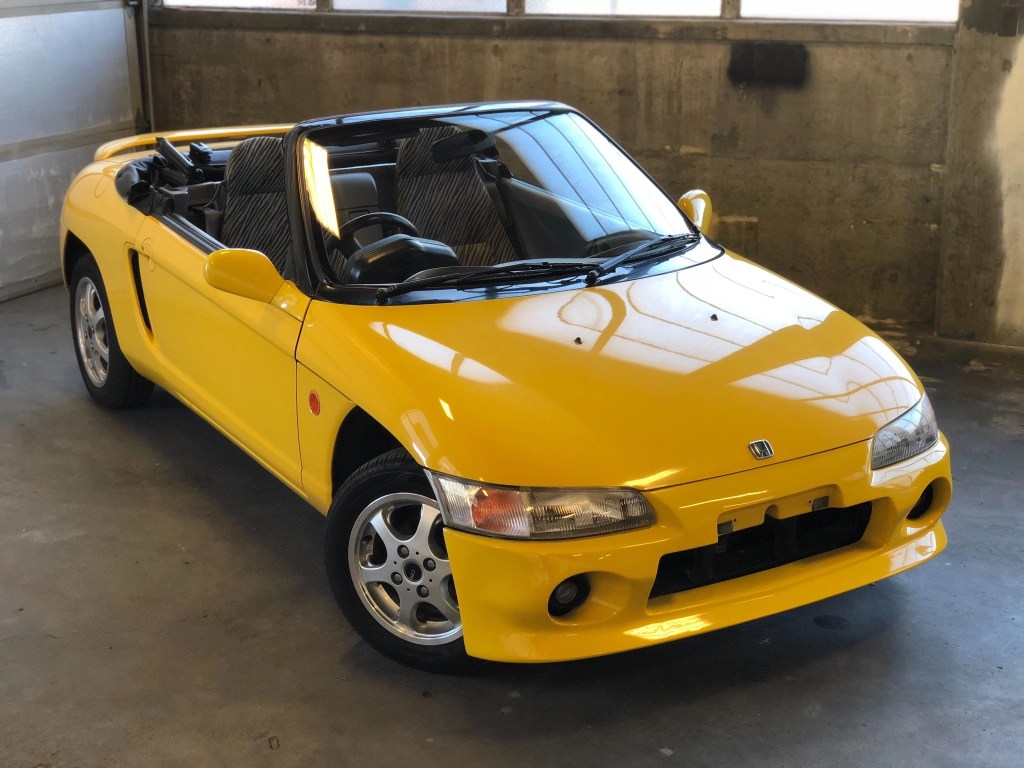 Yellow 1992 Honda Beat with the roof down parked in a garage