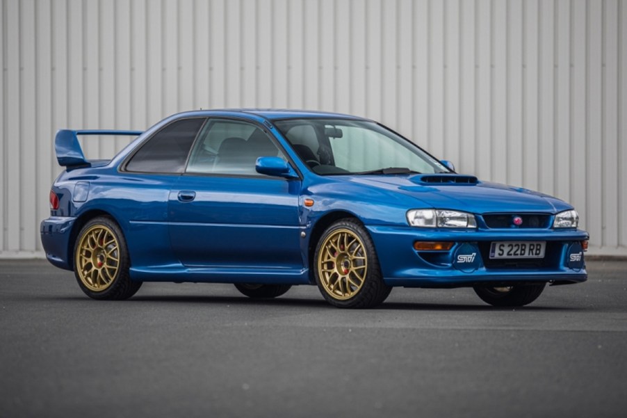 Blue 1998 Subaru Impreza 22B STi in front of a gray metal wall
