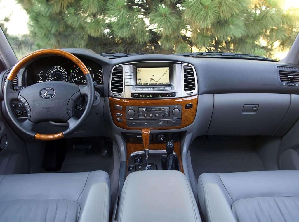 An interior shot of the 2003 Lexus LX470, showing wood trim, navigation screen, and dark-blue leather
