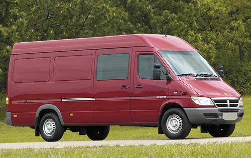 a side view of a red dodge utility van 