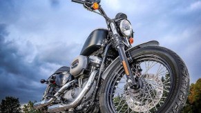 Low-angle shot of a black 2007 Harley-Davidson Sportster 1200 Nightster silhouetted against a cloudy sky