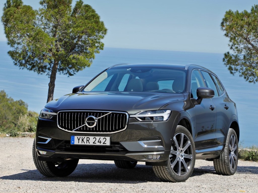 A black Volvo XC60 is parked in a lot overlooking the ocean.