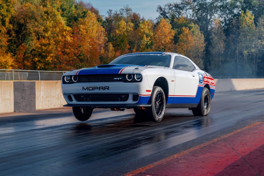 Red-white-and-blue-liveried 2020 Dodge Challenger Drag Pak pulling a wheelie on the drag strip