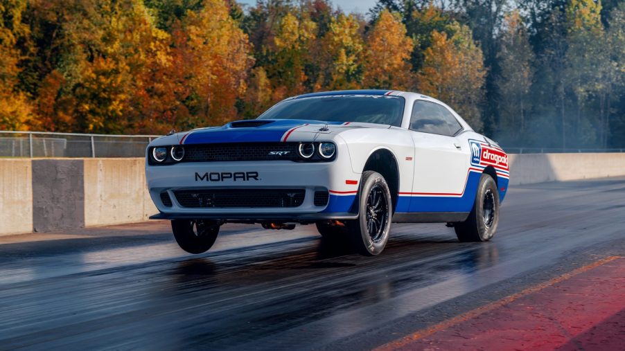 Red-white-and-blue-liveried 2020 Dodge Challenger Drag Pak pulling a wheelie on the drag strip